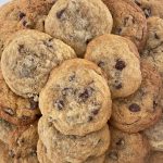 Chocolate chip cookies are piled together.