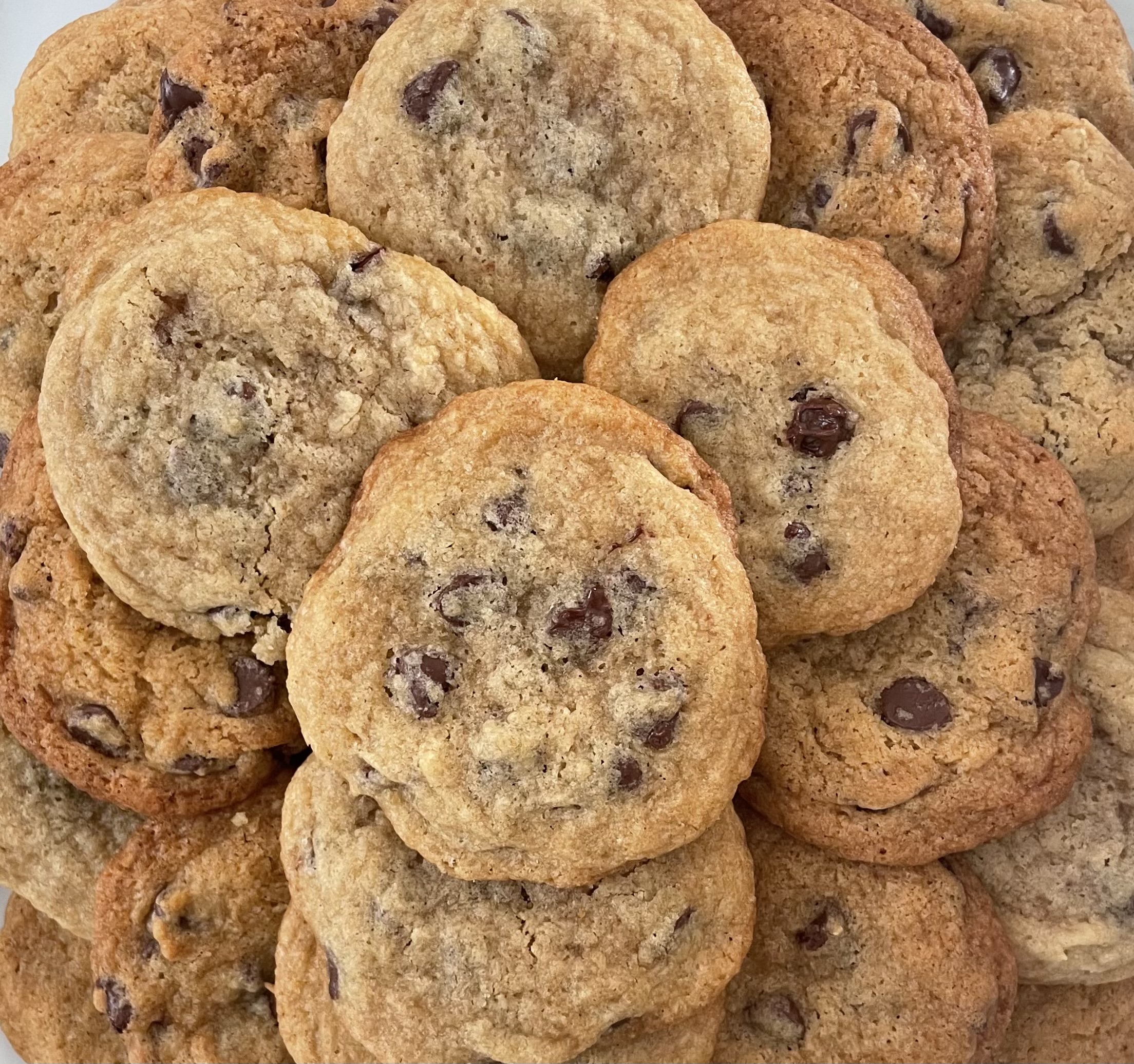 Chocolate chip cookies are piled together.