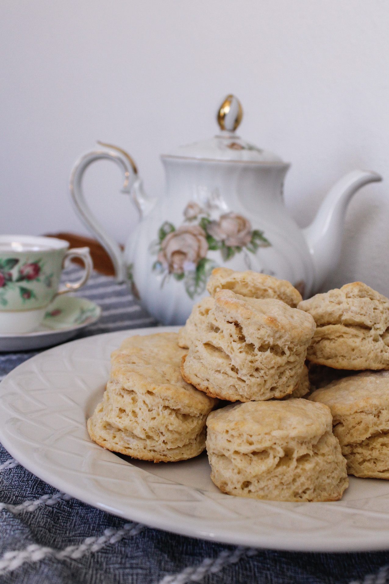 A teapot, tea cup, and plate of freshly-baked scones await.