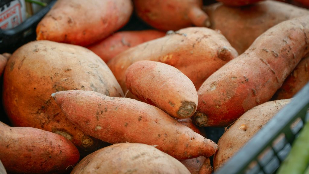Sweet potatoes are piled into a basket.