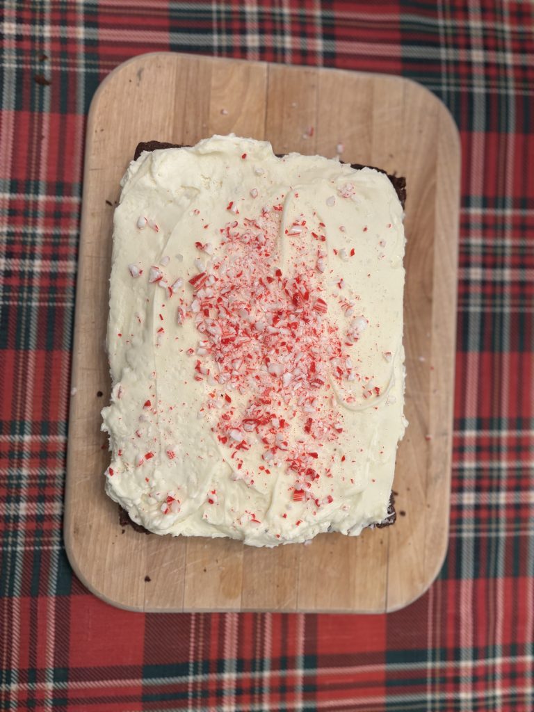 Peppermint cream cheese frosting with crushed peppermint candies tops a batch of brownies.